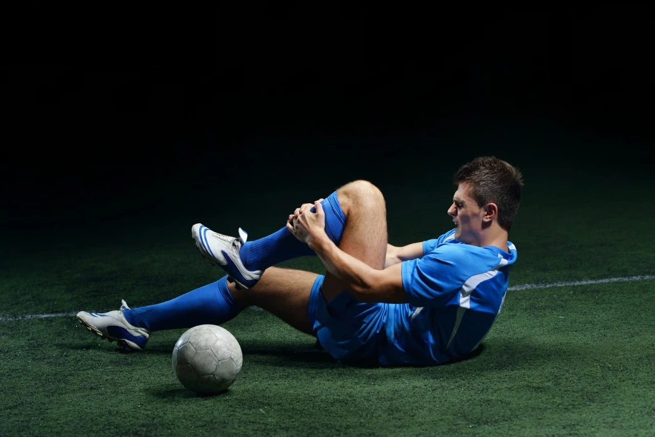 Football player with knee pain after a sports injury